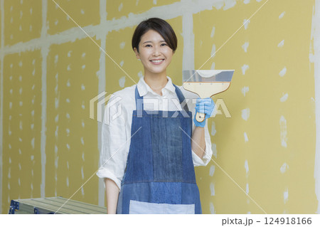 石膏ボードにパテをする女性　 124918166