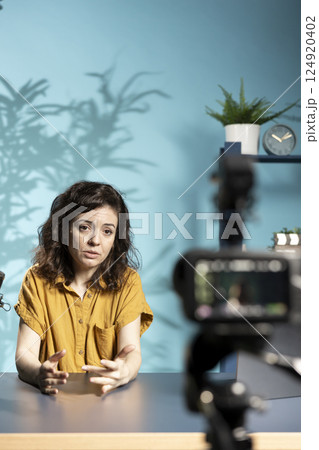 Depressed woman talking with audience about importance of mental health. Upset influencer sulking while hosting internet show, using high tech quality mic recording with professional camera 124920402