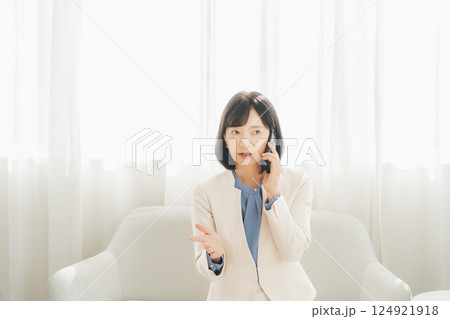 身振り手振りで通話先の相手と話をするミドルキャリアウーマン 身振り手振りで通話先の相手と話をするミドルキャリアウーマン 124921918