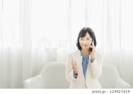 身振り手振りで通話先の相手と話をするミドルキャリアウーマン 身振り手振りで通話先の相手と話をするミドルキャリアウーマン 124921919