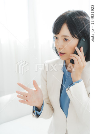身振り手振りで通話先の相手と話をするミドルキャリアウーマン 身振り手振りで通話先の相手と話をするミドルキャリアウーマン 124921922