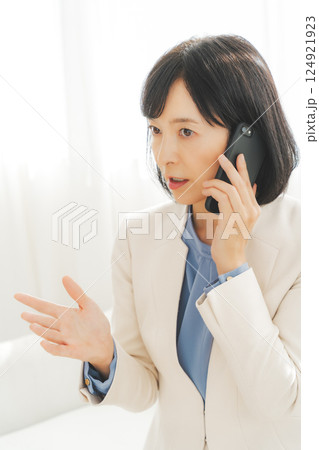 身振り手振りで通話先の相手と話をするミドルキャリアウーマン 身振り手振りで通話先の相手と話をするミドルキャリアウーマン 124921923