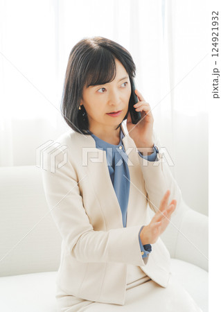 身振り手振りで通話先の相手と話をするミドルキャリアウーマン 身振り手振りで通話先の相手と話をするミドルキャリアウーマン 124921932