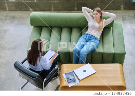 Relaxed young woman lying on sofa in psychologist office at therapy session 124923456