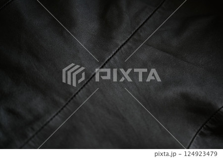 black leather jacket close up, macro black leather jacket texture, soft yet rugged, capturing the grain and stitch details with a worn-in feel	 124923479