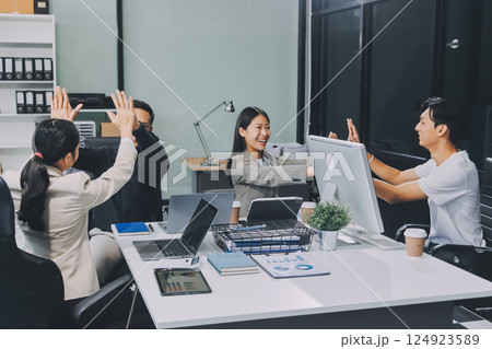 Cheerful meeting room, businesspeople celebrate with handshaking. Successful project was completed before the deadline. Business partnership and collaboration in project management. Habiliment 124923589