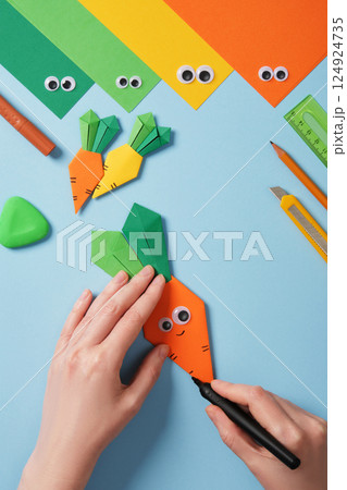 Making origami carrot. DIY project. Draw stripes on the orange part of the carrot. 124924735