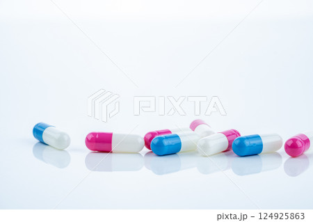 Blue and pink capsule pills spread on white background, showcasing pharmaceutical products, healthcare concepts, and the role of prescription medicine in advancing treatment and patient well-being. 124925863