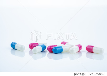 Blue and pink capsule pills spread on white background, showcasing pharmaceutical products, healthcare concepts, and the role of prescription medicine in advancing treatment and patient well-being. 124925882