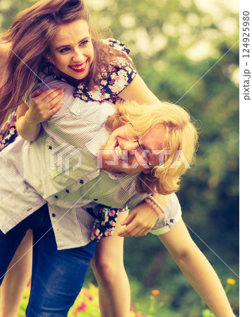couple having fun piggyback riding 124925980