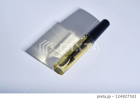 Bottle with brush filled with oil for eyebrow and eyelash growth.  124927381