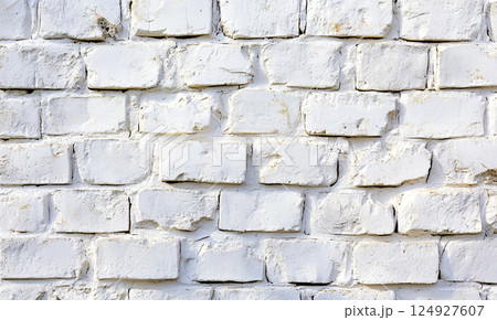 A white-painted brick wall with distinct textures and horizontal alignment, giving a clean yet rustic aesthetic. 124927607