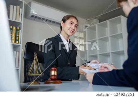 Lawyer consulting with a client, discussing legal documents in a professional office setting 124928251