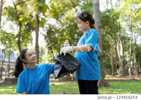 Family members working together to collect garbage during a community volunteer day in the park Family members working together to collect garbage during a community volunteer day in the park 124928254