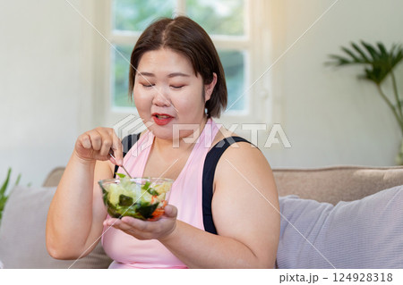 Overweight woman enjoying healthy food at home weight loss journey lifestyle change relaxed environment self care concept Overweight woman enjoying healthy food at home weight loss journey lifestyle change relaxed environment self care concept 124928318