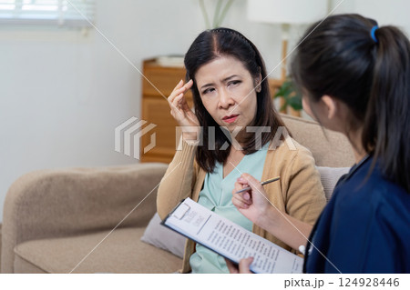 Caregiver checks symptoms of elderly patient with doctor in nursing environment close up view health assessment concept Caregiver checks symptoms of elderly patient with doctor in nursing environment close up view health assessment concept 124928446