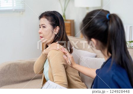 Caregiver checks symptoms of elderly patient with doctor in a cozy home environment Caregiver checks symptoms of elderly patient with doctor in a cozy home environment 124928448
