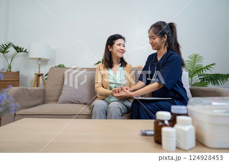 Caregiver checks symptoms of elderly patient with doctor and nurse in home environment 124928453
