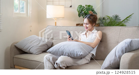 Relaxing woman using smartphone at home modern living room lifestyle cozy environment indoor scene Relaxing woman using smartphone at home modern living room lifestyle cozy environment indoor scene 124928515