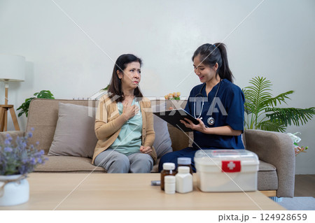 Caregiver assesses elderly patient health home setting medical consultation comfortable environment nurturing concept 124928659