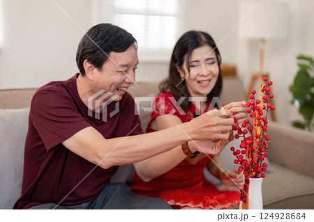 Elderly couple celebrates chinese new year together at home embracing joyful traditions in a cozy environment Elderly couple celebrates chinese new year together at home embracing joyful traditions in a cozy environment 124928684