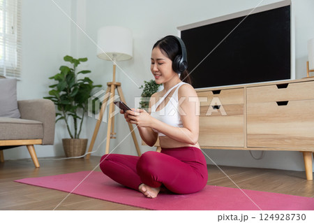 Wellness and Mindfulness. A woman enjoying a moment of relaxation while using her phone. 124928730