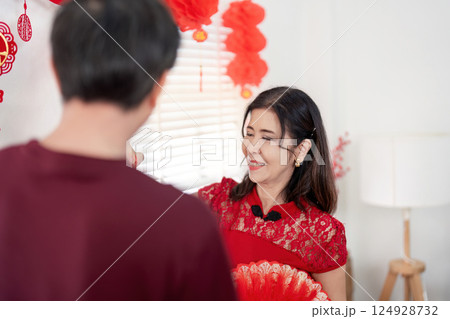 Elderly couple celebrating chinese new year at home embracing traditions in a joyful environment 124928732