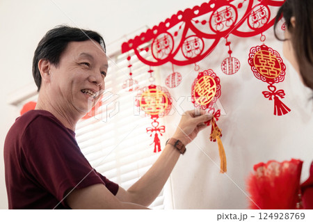 Elderly couple celebrating chinese new year decorations at home warm atmosphere intimate moment joyful tradition 124928769