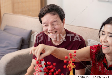 Elderly couple celebrating chinese new year together at home joyful moments captured in a cozy environment 124928771