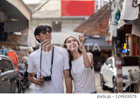 Traveling couple explores vibrant street market urban setting candid moments joyful experience perspective of adventure Traveling couple explores vibrant street market urban setting candid moments joyful experience perspective of adventure 124928879