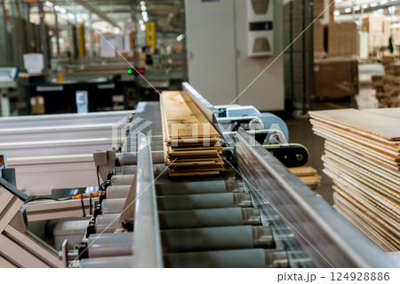 Production line of the wooden floor factory. CNC automatic woodworking machine. Production line of the wooden floor factory. CNC automatic woodworking machine. 124928886