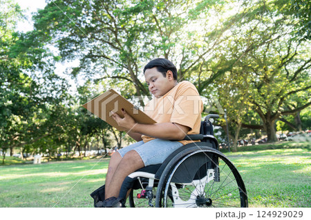 Young Artist in Wheelchair Drawing Outdoors in Sunny Park Surrounded by Lush Greenery and Trees Young Artist in Wheelchair Drawing Outdoors in Sunny Park Surrounded by Lush Greenery and Trees 124929029