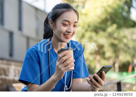 Asian Female Healthcare Worker Relaxing Outdoors with Coffee Asian Female Healthcare Worker Relaxing Outdoors with Coffee 124929050