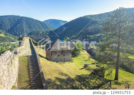 Walled City of Jajce, medieval fortress in Jajce town in Bosnia and Herzegovina, Europe. Historic fortress on green hill, overlooking a valley and mountains on a bright, sunny day with a blue sky. Walled City of Jajce, medieval fortress in Jajce town in Bosnia and Herzegovina, Europe. Historic fortress on green hill, overlooking a valley and mountains on a bright, sunny day with a blue sky. 124931753