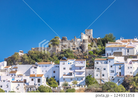 Casares town in Andalusia, Spain, Europe. Whitewashed village nestled against a hilltop castle under a vibrant blue sky. A picturesque scene of traditional architecture and history. Casares town in Andalusia, Spain, Europe. Whitewashed village nestled against a hilltop castle under a vibrant blue sky. A picturesque scene of traditional architecture and history. 124931858