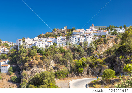 Casares town in Andalusia, Spain, Europe. Whitewashed village perched on a hillside, overlooking a winding road. Sunny day, stunning views. Casares town in Andalusia, Spain, Europe. Whitewashed village perched on a hillside, overlooking a winding road. Sunny day, stunning views. 124931915