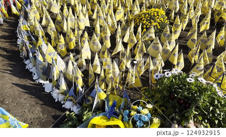 Many small flags of Ukraine with names of the dead war against russia. Memorial of the fallen soldiers, children, women in the center of Kyiv. Concept of tragedy and misfortune. Closeup 124932915