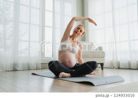Pregnancy yoga fitness workout training. Pregnant woman practicing yoga at home. Pregnant girl doing sports exercise on yoga mat indoor. Woman with big belly have fitness training practicing asana Pregnancy yoga fitness workout training. Pregnant woman practicing yoga at home. Pregnant girl doing sports exercise on yoga mat indoor. Woman with big belly have fitness training practicing asana 124933010