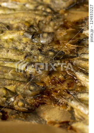 capelin fish fried in oil, stacked in rows cooked hot capelin baked in sunflower oil capelin fish fried in oil, stacked in rows cooked hot capelin baked in sunflower oil 124933227