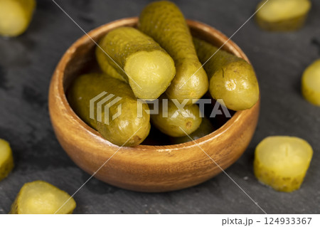 green pickles on the kitchen table, cut small, crispy green cucumbers 124933367