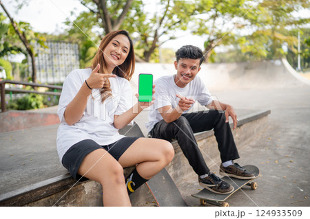 Young skateboarders are having fun on a sunny day at their local skate park 124933509