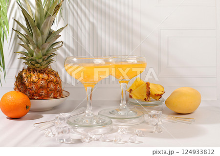 Homemade cocktail or lemonade with pineapple, orange, ice on sunny kitchen table. Refreshing summer diet drink recipe, Detox diet and summer party concept. Restaurant menu, 124933812