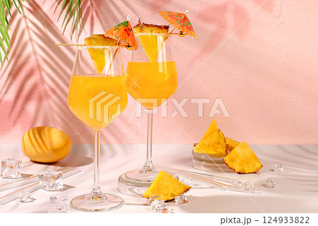 Summer party concept. Lemonade royal cocktail, martini or punch made of tequila, rum and vodka with pineapple slices, orange, ice. Diet drink for advertising a bar or cafe, restaurant menu. 124933822