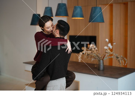 Couple sharing a sweet moment in modern home setting with warm lighting Couple sharing a sweet moment in modern home setting with warm lighting 124934113
