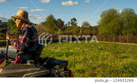 Man on riding lawn mower 124935269