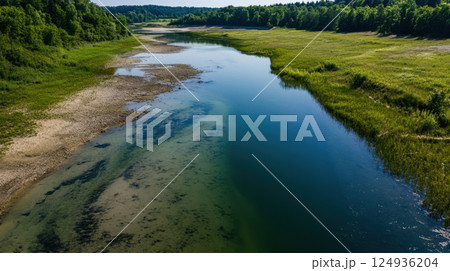 serene river landscape with lush greenery and drained riverbed 124936204