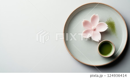 Delicate Japanese dessert with matcha tea and flower on plate 124936414