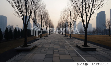 serene urban park with bare trees lining pathway, creating tranquil atmosphere 124936692