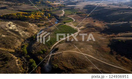 Aerial view of dry landscape with winding paths and sparse vegetation Aerial view of dry landscape with winding paths and sparse vegetation 124936951