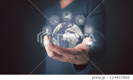 holds globe representing interconnect of the digital world. Icons for search, graphs,shopping carts,light bulbs,and more surround the world, symbol the vast possibilities of technology and business. 124937808